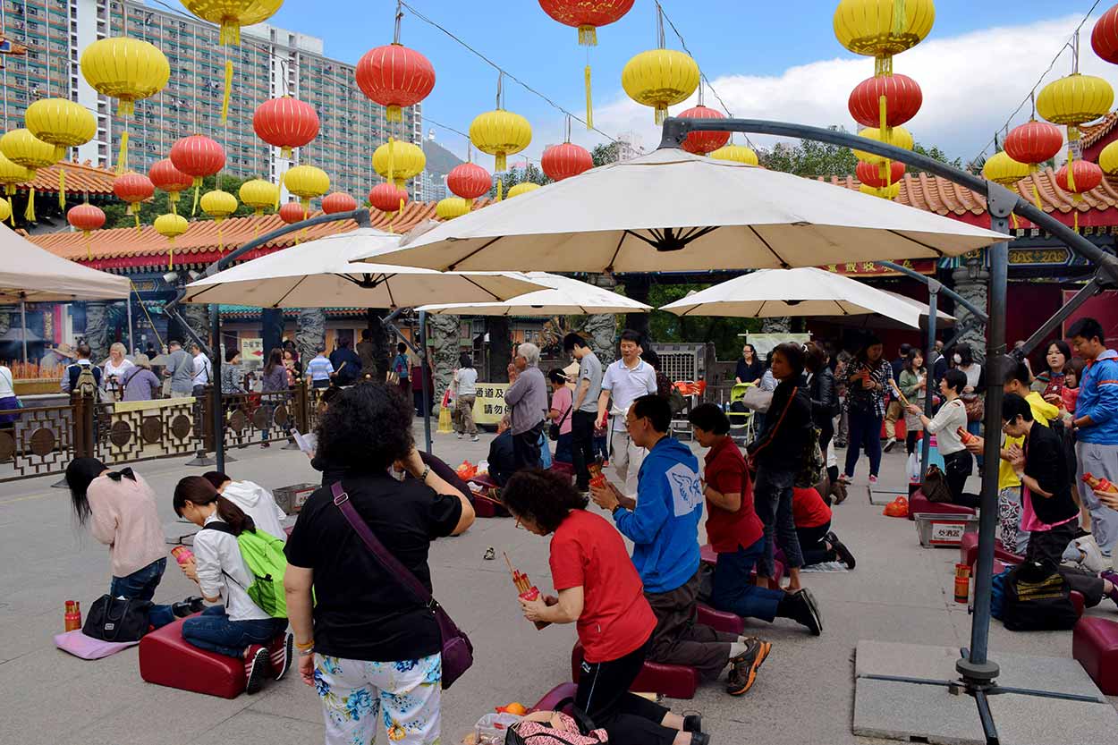 Worshippers shaking a bamboo cylinder containing fortune sticks, Sik Sik Yuen Wong Tai Sin Temple, Hong Kong, China